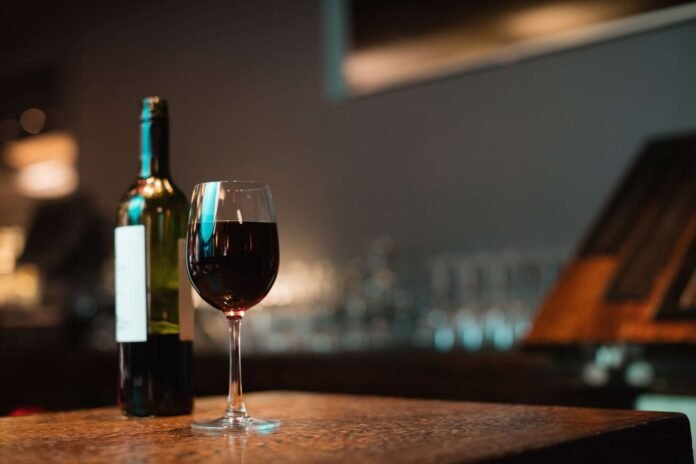 copo-de-vinho-tinto-e-garrafa-no-balcao-de-bar (1)